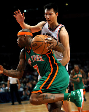 Yi Jianlian (back) of New Jersey Nets defenses Al Harrington of New York Knicks during a NBA basketball match in New York, the United States, March 18, 2009. Nets won the match 115-89.