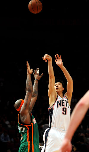 Yi Jianlian (R) of New Jersey Nets shoots during a NBA basketball match agaisnt New York Knicks in New York, the United States, March 18, 2009. Nets won the match 115-89.