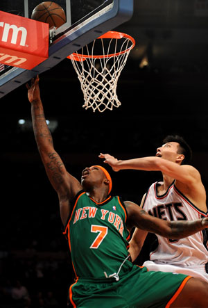  Yi Jianlian (R) of New Jersey Nets and Al Harrington of New York Knicks vies for a rebound during a NBA basketball match in New York, the United States, March 18, 2009. Nets won the match 115-89.