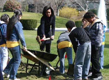 U.S. first lady Michelle Obama (C) joins 5th grade students from the Bancroft Elementary School during a groundbreaking ceremony for the new White House Kitchen Garden in Washington, March 20, 2009. The garden will grow about 25 varieties of fruits and vegetables which will be harvested by the White House kitchen for consumption at the White House. [Xinhua/Reuters]