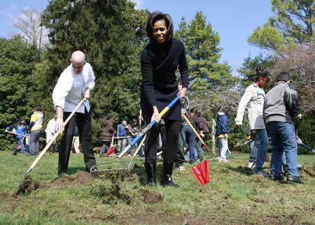 First lady Michelle Obama, accompanied by students from Washington's Bancroft Elementary School, takes part in groundbreaking of the White House 'kitchen gardenon,' Friday, March 20, 2009, on the South Lawn of the White House in Washington. [Xinhua/Reuters]