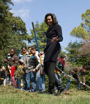 First lady Michelle Obama, accompanied by students from Washington's Bancroft Elementary School, takes part in groundbreaking of the White House 'kitchen gardenon,' Friday, March 20, 2009, on the South Lawn of the White House in Washington. [Xinhua/Reuters]