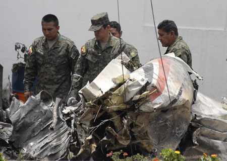 Ecuadoran soldiers look airplane wreckage crashed in Quito, capital of Ecuador, Mar. 20, 2009. A small military plane hit part of one building in the northern part of the city before crashing into another building next to U.S. ambassador's residence in Quito on Thursday, killing seven people. [Xinhua] 