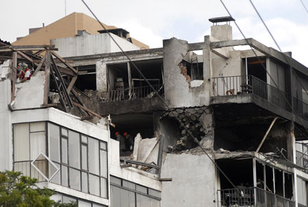  Photo taken on March 20, 2009 shows the building hit by a plane in Quito, capital of Ecuador. A small military plane hit part of one building in the northern part of the city before crashing into another building next to U.S. ambassador's residence in Quito on Thursday, killing seven people. [Xinhua]