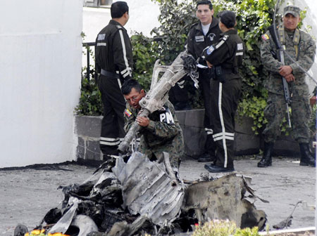 An Ecuadoran soldier carrys a wreckage of a crashed airplane in Quito, capital of Ecuador, Mar. 20, 2009. A small military plane hit part of one building in the northern part of the city before crashing into another building next to U.S. ambassador's residence in Quito on Thursday, killing seven people. [Xinhua]