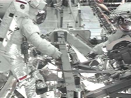 A NASA videograb on Saturday, March 21, 2009, shows space shuttle Discovery astronauts Joseph Acaba (L) and Steven Swanson complete second spacewalk.[Xinhua/AFP]