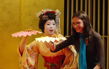 A foreign tourist follows a geisha to play a traditional Japanese game in Tokyo, capital of Japan, March 21, 2009.