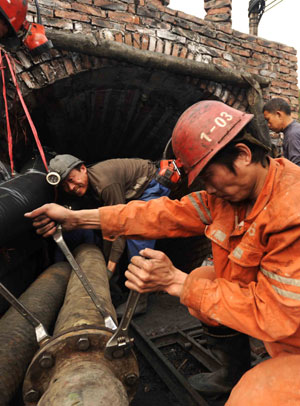 Rescuers prepare pipes to draw water from a flooded coal mine in Sanjiaotang Township of Changning, a city in central-south China's Hunan Province, March 21, 2009. An estimated 13 miners were still trapped one day after a colliery flood in central China's Hunan Province, rescuers said Mar. 22. [Li Ga/Xinhua]