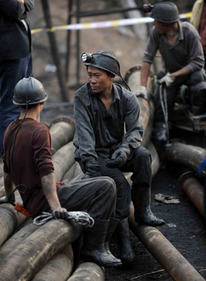 Miners wait for news about their trapped colleagues at a flooded coal mine in Sanjiaotang Township of Changning, a city in central-south China's Hunan Province, March 21, 2009. [Li Ga/Xinhua]