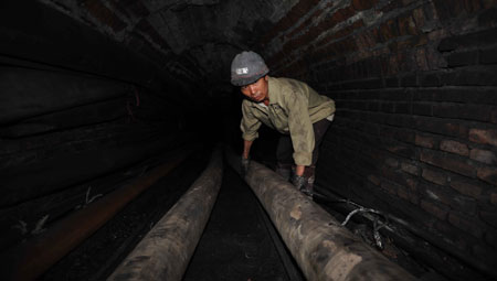 A rescuer prepares pipes to draw water from a flooded coal mine in Sanjiaotang Township of Changning, a city in central-south China's Hunan Province, March 21, 2009. [Li Ga/Xinhua]