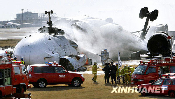 Emergency workers are seen at the nose section of a crashed cargo plane at Narita international airport in Chiba, Japan March 23, 2009. [Xinhua]