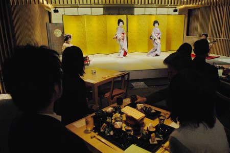 Tourists watch geishas' performance in Tokyo, capital of Japan, March 21, 2009. The Japanese government, with traditional art and unique culture of food to attract more and more foreign tourists, has planned to raise the number of foreign tourists visiting Japan to 20 million in 2020. [Qian Zheng/Xinhua]