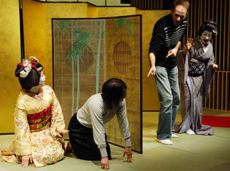 Tourists follow geishas to play a traditional Japanese game in Tokyo, capital of Japan, March 21, 2009. The Japanese government, with traditional art and unique culture of food to attract more and more foreign tourists, has planned to raise the number of foreign tourists visiting Japan to 20 million in 2020. [Sun Wei/Xinhua]