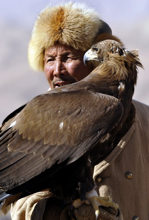  A Kirgiz herder displays his falcon during the Second Falcon Cultural Festival in Akqi county, northwest China's Xinjiang Uygur autonomous region on March 21, 2009. [Xinhua]