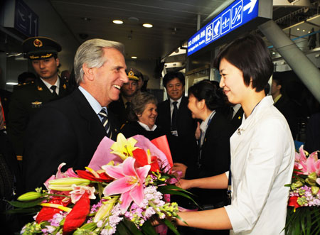 Uruguay's President Tabare Vazquez (L, front) receives flowers upon his arrival at the Beijing Capital International Airport, in Beijing, capital of China, Mar. 21, 2009 for a six-day state visit to China. [Xie Huanchi/Xinhua]