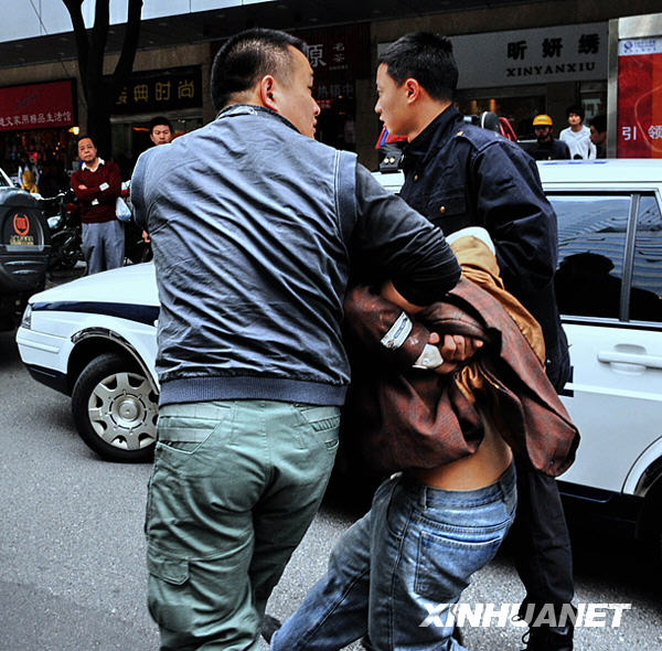 The man who took three women as hostages for more than three hours inside a pawn shop is captured by policemen in Fuzhou, capital of southeast China's Fujian Province, March 23, 2009. [Xinhua]