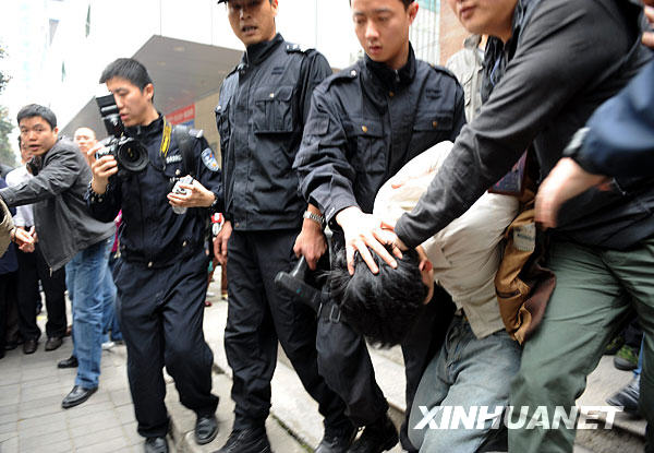  The man who took three women as hostages for more than three hours inside a pawn shop is captured by policemen in Fuzhou, capital of southeast China's Fujian Province, March 23, 2009. [Xinhua]