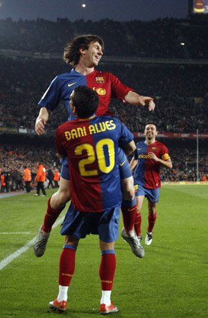 Barcelona's Dani Alves (down) and Lionel Messi (up) celebrate a goal against Malaga during their Spanish First Division soccer league match at Nou Camp Stadium in Barcelona, March 22, 2009.(Xinhua/Reuters photo) 