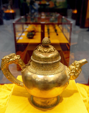 An aureate carving silvern pot made in ancient China's Qing Dynasty (1644-1911) is seen in the Exhibition of Essence of Tibetan Intangible Cultural Heritage in Macao, south China, March 20, 2009. The five-day exhibition was opened here on Friday, displaying 99 exhibits that are of Tibetan cultural importance. [Xinhua photo]