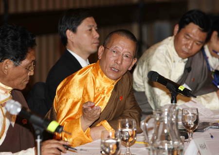 Shingtsa Tenzinchodrak (C), a living Buddha of Tibetan Buddhism and head of the delegation of the Tibetan deputies to China's National People's Congress, answers questions by reporters in Toronto March 20, 2009. The delegation arrived in Toronto on Friday after their six-day visit to the United States. [Xinhua photo]