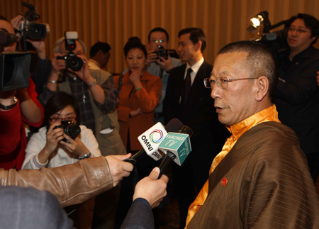 Shingtsa Tenzinchodrak (R), a living Buddha of Tibetan Buddhism and head of the delegation of the Tibetan deputies to China's National People's Congress, answers questions by reporters in Toronto March 20, 2009. The delegation arrived in Toronto on Friday after their six-day visit to the United States. [Xinhua photo]