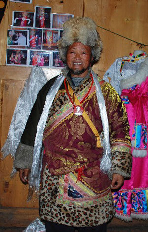 Photo taken on Jan. 13, 2009, shows Tashi, host of Losang Nyima Linka, wearing a Tibetan costume and a badge of Chairman Mao Zedong. [Xinhua photo]