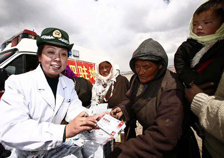 A doctor of the General Armed Police Hospital of Tibet hand out medicines for Yangyi villagers in Geda Town, Damxung County, Lhasa City, on March 18. The hospital sent a team of experts on a tour providing medical treatment for those injured in a quake in the Yangyi village while teaching local residents how to prevent and treat common diseases in spring. [Xinhua photo]