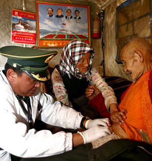 Photo taken on March 18 shows a doctor of the General Armed Police Hospital of Tibet changes catheter for the 75-year-old Yangyi villager Jinba in Geda Town, Damxung County, Lhasa, Tibet. [Xinhua photo]