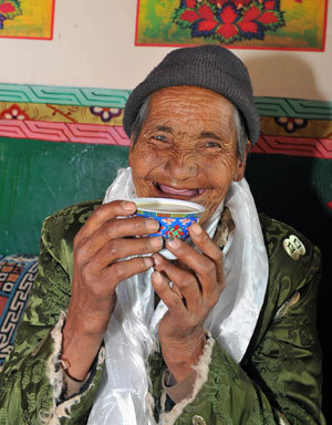 An elderly woman who used to be a serf in Old Tibet drinks buttered tea at her house in a village in Qamdo, southwest China's Tibet Autonomous Region, March 22, 2009. China will celebrate its first Serfs Emancipation Day on March 28. [Xinhua photo]