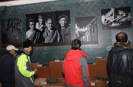 Photo taken in Beijing on March 22, 2009 shows visitors look at exhibits on display during an exhibition marking the 50th Anniversary of Democratic Reforms in Tibet. Since its opening on February 24, the exhibition has received more than 100,000 visitors. It is estimated that the 50-day exhibit will attract some 200,000 visitors in total. [Xinhua photo]