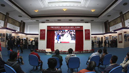 Photo taken in Beijing on March 22, 2009 shows visitors watch a documentary during an exhibition marking the 50th Anniversary of Democratic Reform in Tibet. [Xinhua photo]