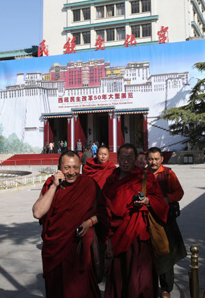 Photo taken on March 22, 2009 shows Tibetan monks walk out of the Cultural Palace of Nationalities in Beijing after visiting an exhibition marking the 50th Anniversary of Democratic Reform in Tibet. [Xinhua photo]