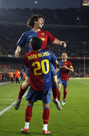 Barcelona's Dani Alves (down) and Lionel Messi (up) celebrate a goal against Malaga during their Spanish First Division soccer league match at Nou Camp Stadium in Barcelona, March 22, 2009.[Xinhua/Reuters]