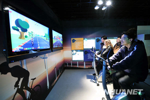 Visitors ride the pneumatic bicycle to experience the variation of air resistance under various wind speed, inside the Meteorologic Popular Science Hall for Public Experience, which opens to mark the World Meteorological Day, in Hangzhou, capital of east China's Zhejiang Province, March 23, 2009.[Li Zhong/Xinhua]