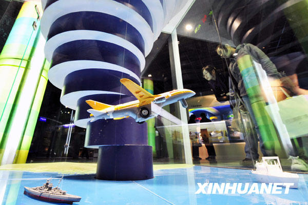 Visitors observe the model illustrating the earth's atmosphere strata, inside the Meteorologic Popular Science Hall for Public Experience, which opens to mark the World Meteorological Day, in Hangzhou, capital of east China's Zhejiang Province, March 23, 2009.[Li Zhong/Xinhua]