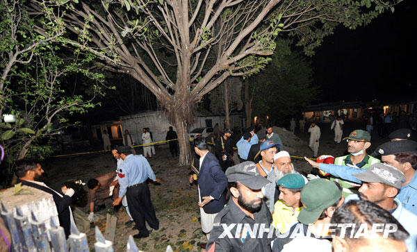 Pakistani security and rescue officials gather at the site of a suicide attack in Islamabad on March 23, 2009. A suspected suicide bomb ripped through a police office in the centre of Pakistan's capital Islamabad, causing casualties, a police official said.[xinhua/AFP]