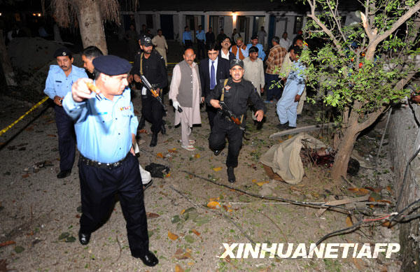 Pakistani security and rescue officials gather at the site of a suicide attack in Islamabad on March 23, 2009. A suspected suicide bomb ripped through a police office in the centre of Pakistan's capital Islamabad, causing casualties, a police official said.[xinhua/AFP]