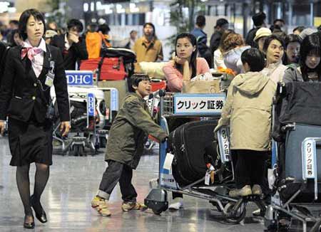 Passengers wait to check-in at the departure area of Narita international airport March 23, 2009. A FedEx Corp cargo plane caught in a gust of wind crashed and burst into flames as it landed at Narita international airport on Monday, closing the main runway at the busy gateway to Tokyo. [Xinhua/AFP]