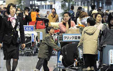 Passengers wait to check-in at the departure area of Narita international airport March 23, 2009. A FedEx Corp cargo plane caught in a gust of wind crashed and burst into flames as it landed at Narita international airport on Monday, closing the main runway at the busy gateway to Tokyo. [Xinhua/AFP]