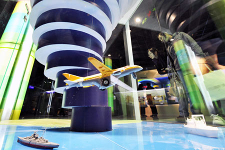 Visitors observe the model illustrating the earth's atmosphere strata, inside the Meteorologic Popular Science Hall for Public Experience, which opens to mark the World Meteorological Day, in Hangzhou, capital of east China's Zhejiang Province, March 23, 2009. [Li Zhong/Xinhua]