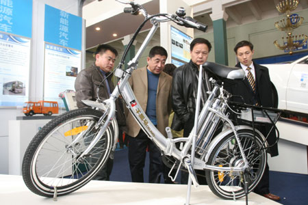 Visitors view a bicycle with power supply from hydrogen fuel cells during the China International Energy Saving, Emission Reduction and New Energy Science and Technology Expo at the Beijing Exhibition Center in Beijing, capital of China, March 22, 2009. [Chen Xiaogen/Xinhua]