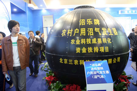 Visitors view a marsh gas generator during the China International Energy Saving, Emission Reduction and New Energy Science and Technology Expo at the Beijing Exhibition Center in Beijing, capital of China, March 22, 2009. [Chen Xiaogen/Xinhua] 