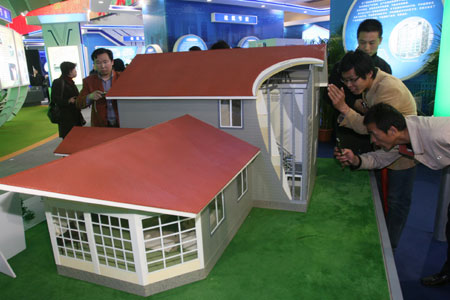 Visitors views an ecological farm house model featuring earthquake resistance and energy saving during the China International Energy Saving, Emission Reduction and New Energy Science and Technology Expo at the Beijing Exhibition Center in Beijing, capital of China, March 22, 2009. [Chen Xiaogen/Xinhua]