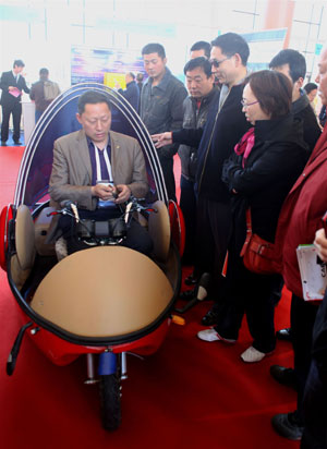 An exhibitor shows an electric vehicle during the China International Energy Saving, Emission Reduction and New Energy Science and Technology Expo at the Beijing Exhibition Center in Beijing, capital of China, March 22, 2009. More than 200 companies and organizations took part in the five-day expo, opened on March 19. [Luo Wei/Xinhua]