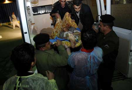 A man wounded in a suicide bombing in Jalulu, 125 kilometers (80 miles) northeast of Baghdad, Iraq, is helped by medics at a hospital in Sulaimaniyah, Iraq, Monday, March 23, 2009. 