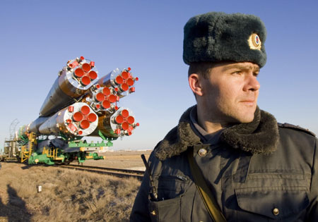  A Russian policeman guards the Soyuz TMA-14 spacecraft as it is transported to its launch pad at Baikonur cosmodrome March 24, 2009. The spacecraft is scheduled to take U.S. entrepreneur Charles Simonyi, Russian cosmonaut Gennady Padalka and U.S. astronaut Michael Barratt to the International Space Station (ISS) on Thursday.[Xinhua/Reuters]