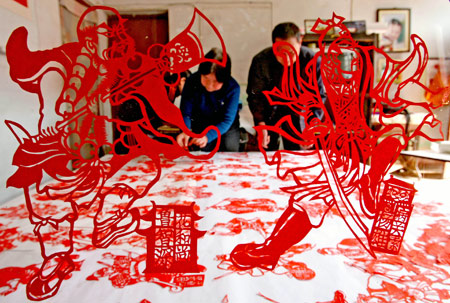 Folk artist Wang Zhenzhu displays her paper-cuttings of 108 generals of Chinese classic novel 'Outlaws of the Marsh', in Yuncheng, north China's Shanxi Province, March 24, 2009. It took Wang Zhenzhu some three months to finish the vivid paper-cuttings of aesthetic value. [Xinhua]