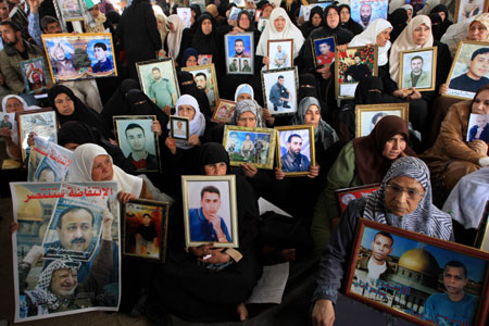 Palestinian women hold the portraits of their jailed relatives during a protest to demand the release of Palestinian prisoners held in Israeli jails, in Gaza City, March 23, 2009. Israeli officials met with Hamas prisoners over the past few days to discuss a prisoner exchange deal that would secure the release of an Israeli soldier held captive in the Gaza Strip for over 1,000 days, a Palestinian news agency reported Monday. [Xinhua]