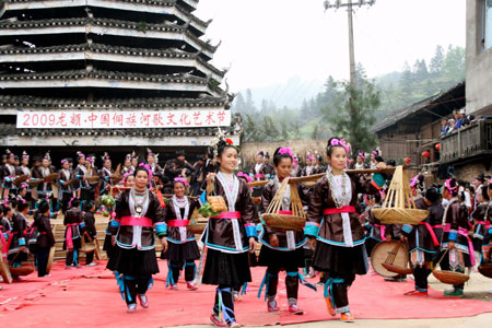 Women of the Dong ethnic group perform dancing during a traditional cultural and art festival at the drum-tower of the Long'e Village of Liping County, southwest China's Guizhou Province, March 23, 2009. The 3-day 2009 Long'e China Singing Cultural and Art Festival of the Dong Ethnic Group started at the Long'e Village on Monday. [Chen Peiliang/Xinhua]