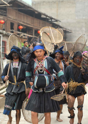 People of the Dong ethnic group carry fishnet to take part in a fishing contest during a traditional cultural and art festival at the Long'e Village of Liping County, southwest China's Guizhou Province, March 23, 2009. The 3-day 2009 Long'e China Singing Cultural and Art Festival of the Dong Ethnic Group started at the Long'e Village on Monday. [Chen Peiliang/Xinhua]